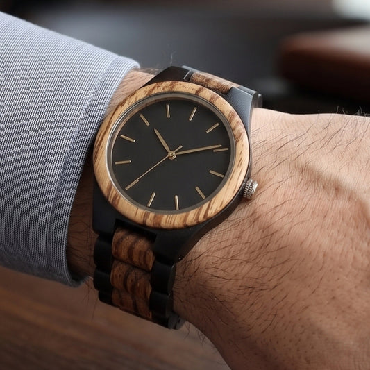Men's wristwatch with zebrawood and black strap; black dial with slim gold baton markers.
