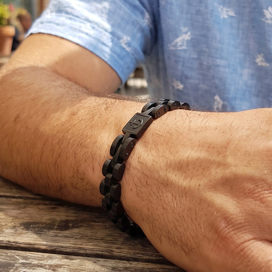 Men's black stainless steel anchor bracelet on wrist with engraved link details