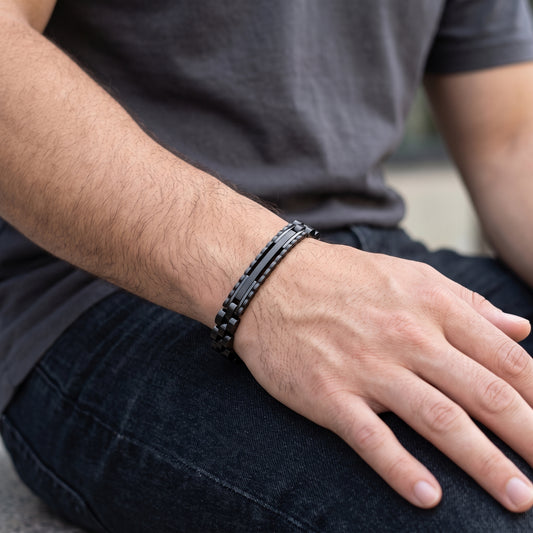 Black stainless steel ID link bracelet on wrist over dark clothing