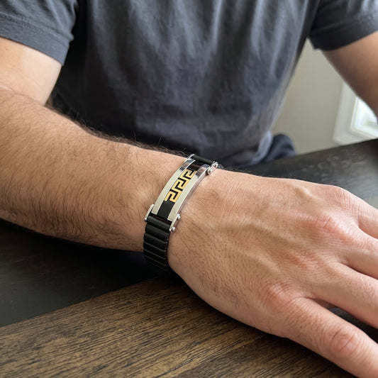 Stainless steel Greek key bracelet with black link band and silver clasp, on wrist