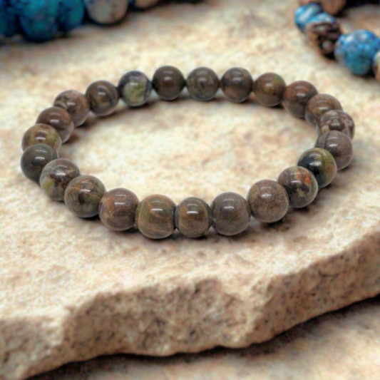 Men's beaded stone bracelet with round dark brown beads and subtle green patterns.