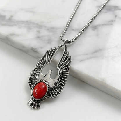 Silver-tone eagle pendant necklace with red oval stone and textured wings on chain