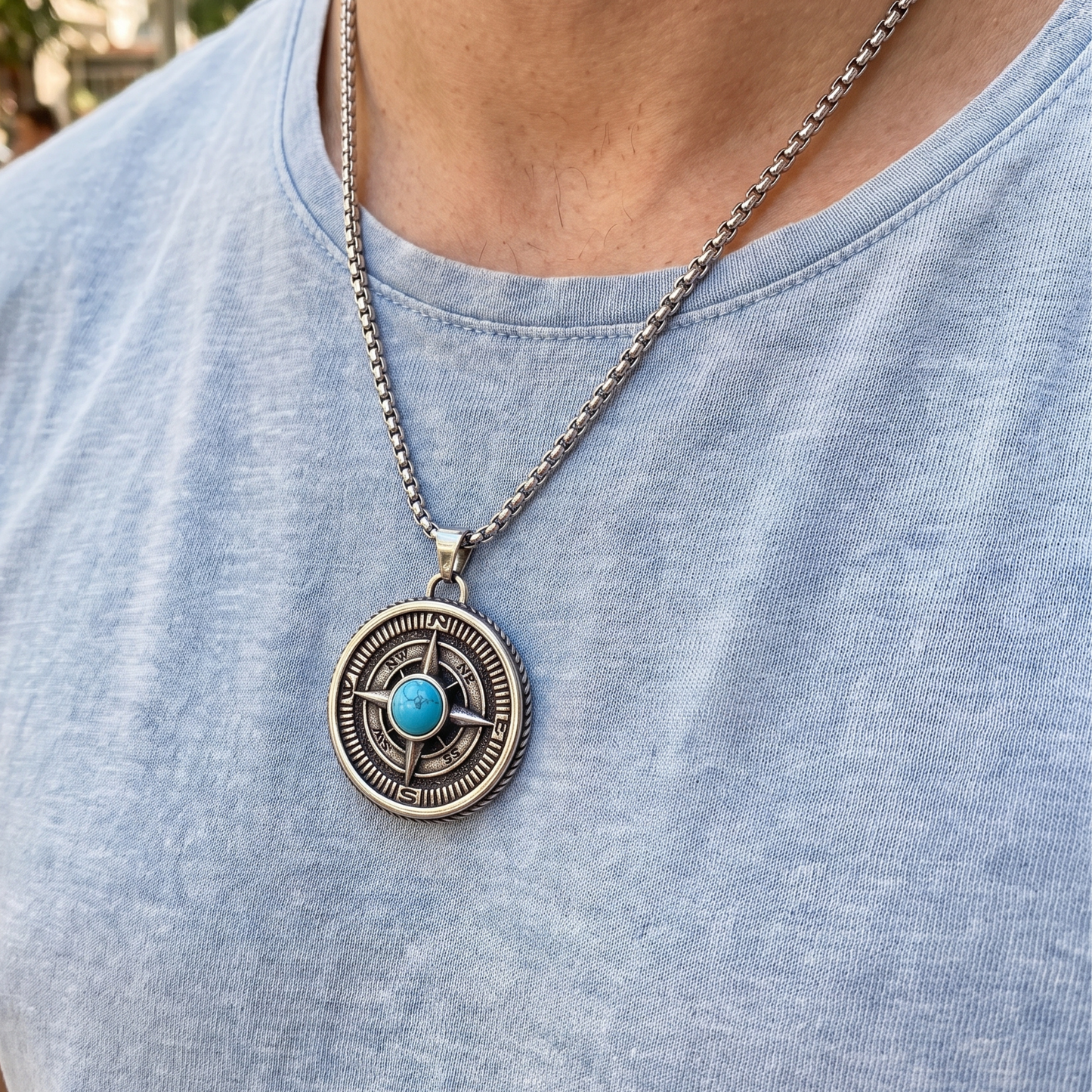 Turquoise compass pendant necklace worn on blue crewneck shirt