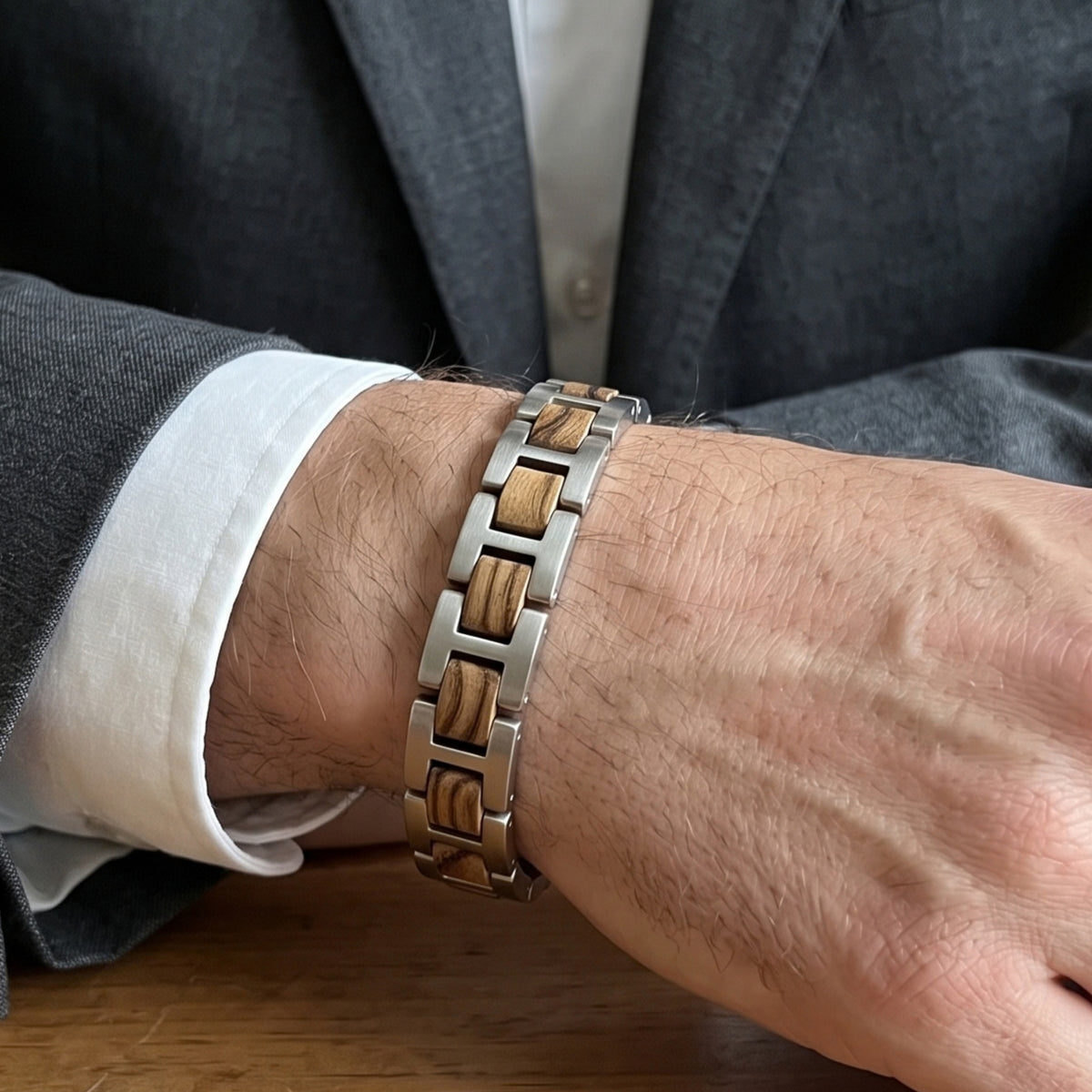 Zebrawood and stainless steel bracelet on wrist with dark suit jacket, Overpowered Accessories