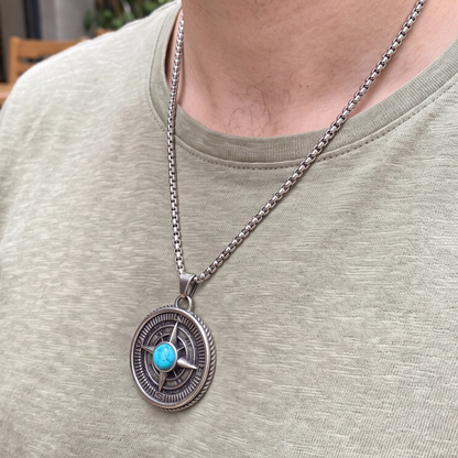 Round compass pendant necklace on silver chain with blue turquoise cabochon and carved rim