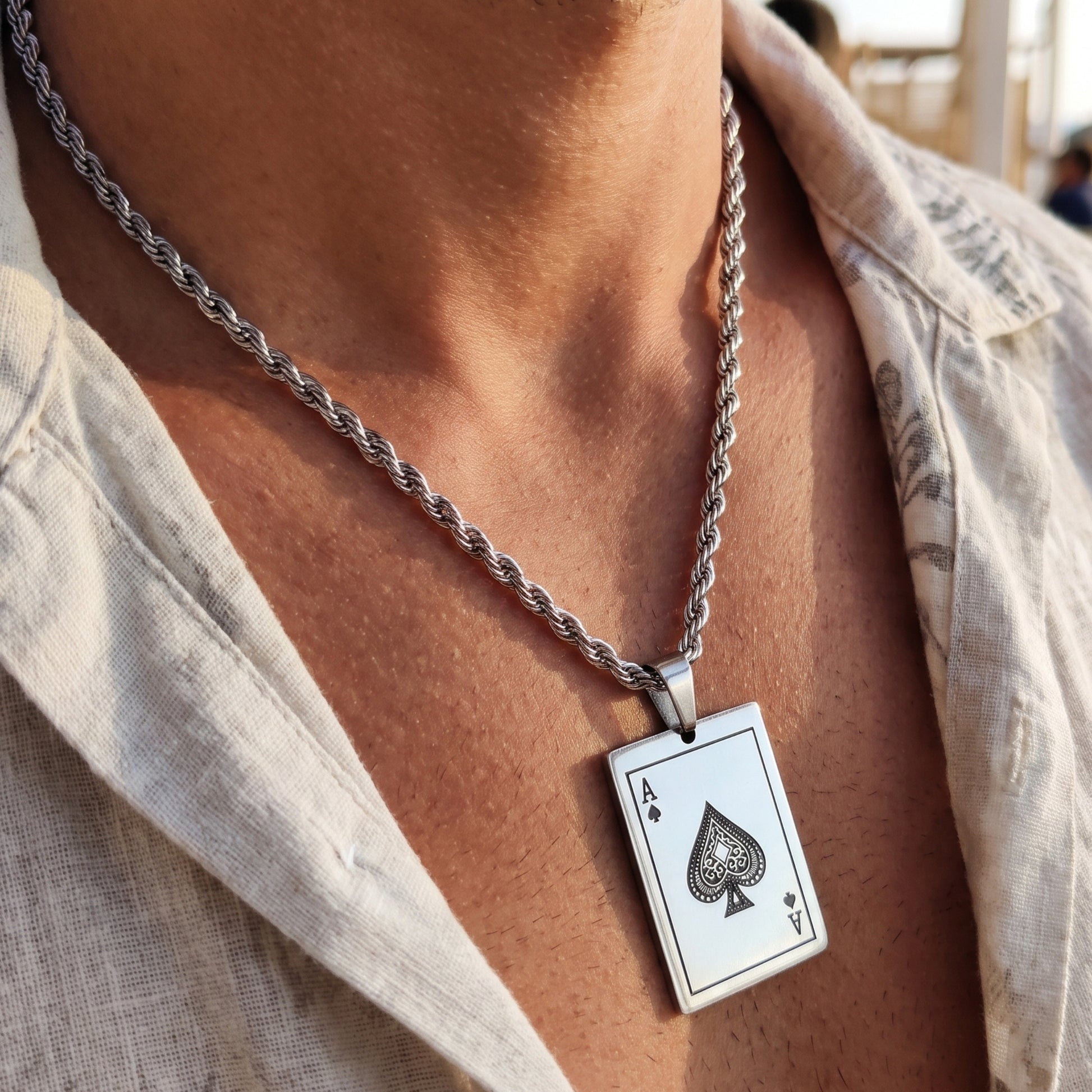 Silver chain necklace with square Ace of spades card pendant on chest