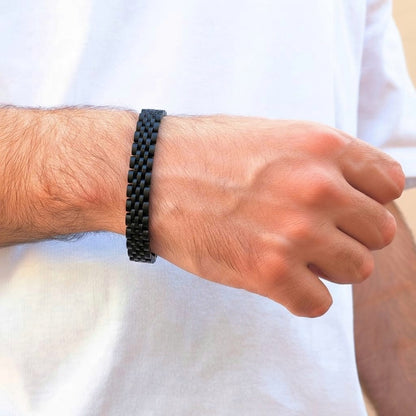 Sleek Black Stainless Steel B-16 Bracelet worn on a man's wrist, showcasing a modern woven design.