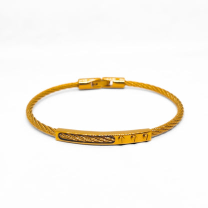 Gold bracelet with a textured band on a white background