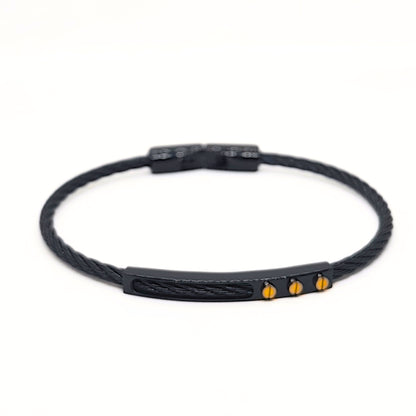 Black braided bracelet with gold accents on a white background