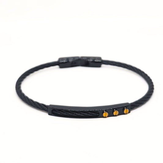 Black braided bracelet with gold accents on a white background
