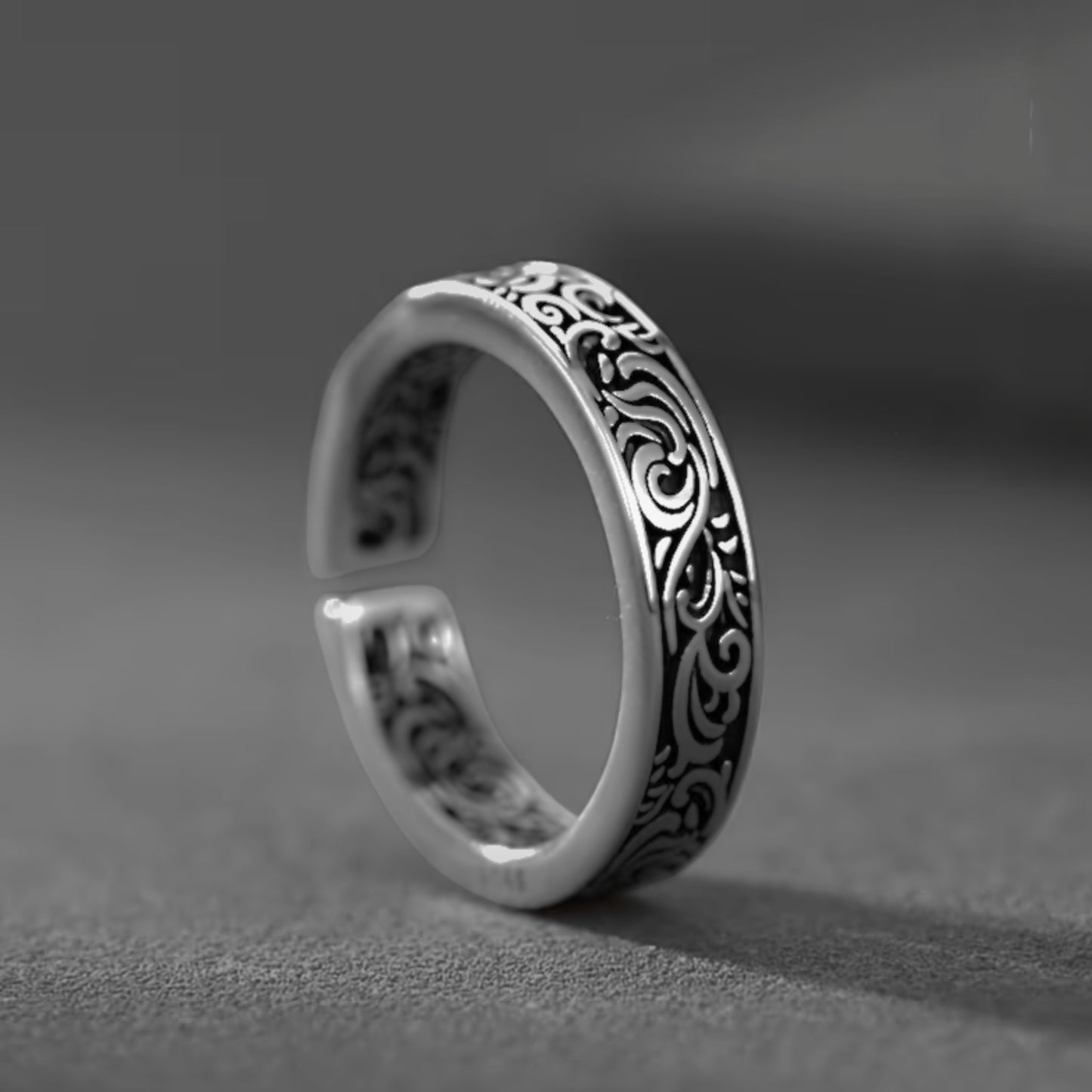 Silver tone men’s ring with black scrollwork inlay along the band