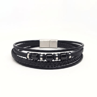 A black multi-strand leather bracelet featuring a braided section, smooth wrap-around cords, glossy black beads, and a silver-toned rectangular clasp, shown on a plain white background.