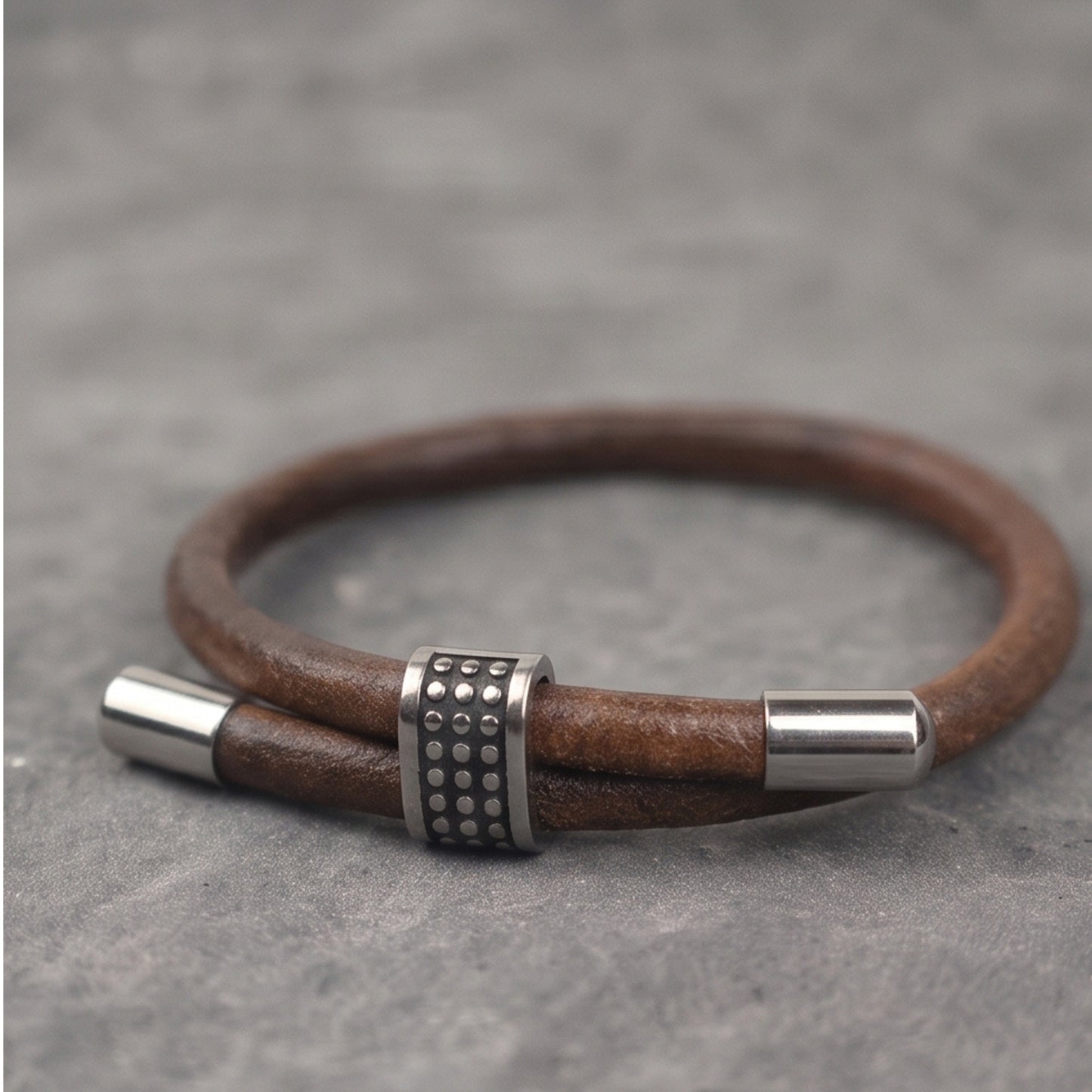Men's brown leather bracelet with silver end caps and studded metal center