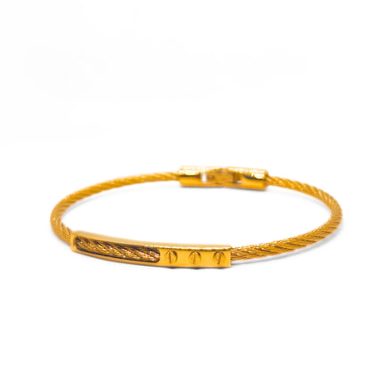 Gold bracelet with a textured band on a white background