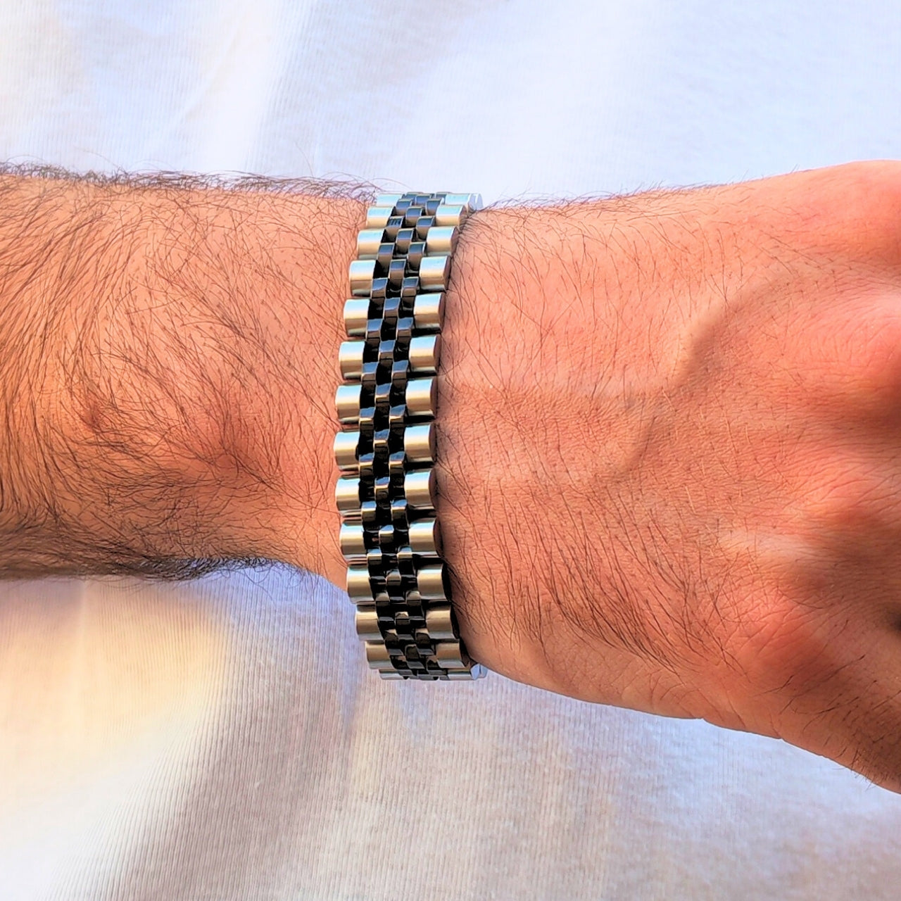 Two-tone silver and black stainless steel B-53 bracelet worn on a wrist, showcasing a sleek, modern design.