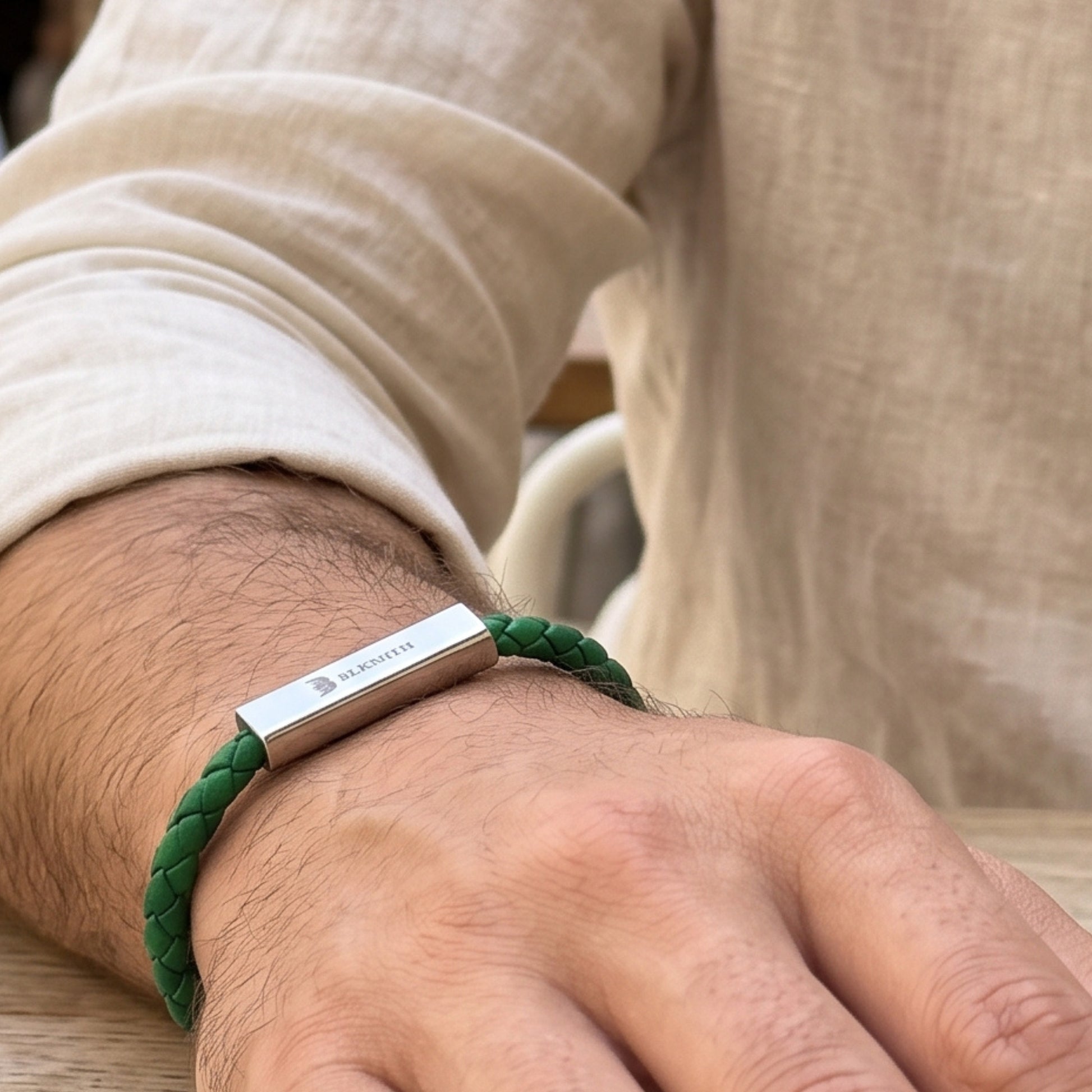 Green braided leather bracelet with silver bar clasp and engraved brand detail
