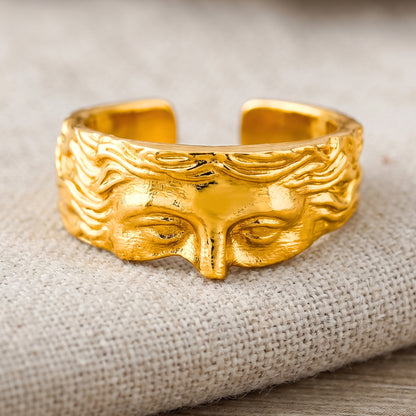 Gold sculpted face ring with set eyes, engraved hair waves, wide band