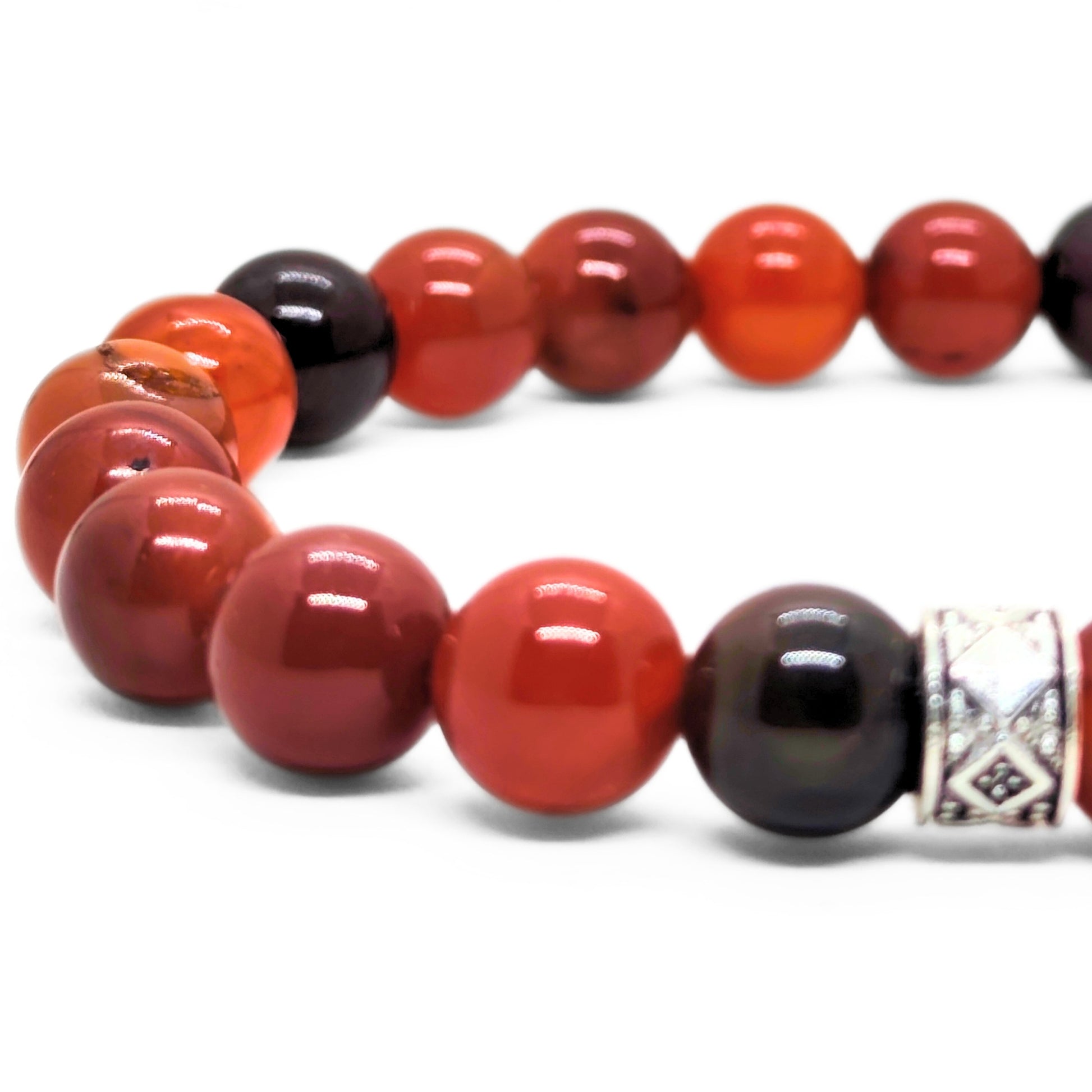 Close-up of red agate bead bracelet with dark beads and silver geometric charm