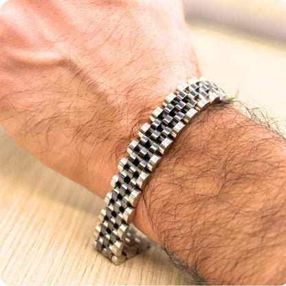 Two-tone silver and black stainless steel B-53 bracelet worn on a man's wrist, showcasing a woven design.