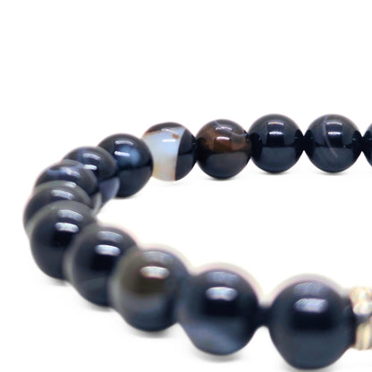 Men's agate bead bracelet close-up with dark blue beads and gold-tone spacer