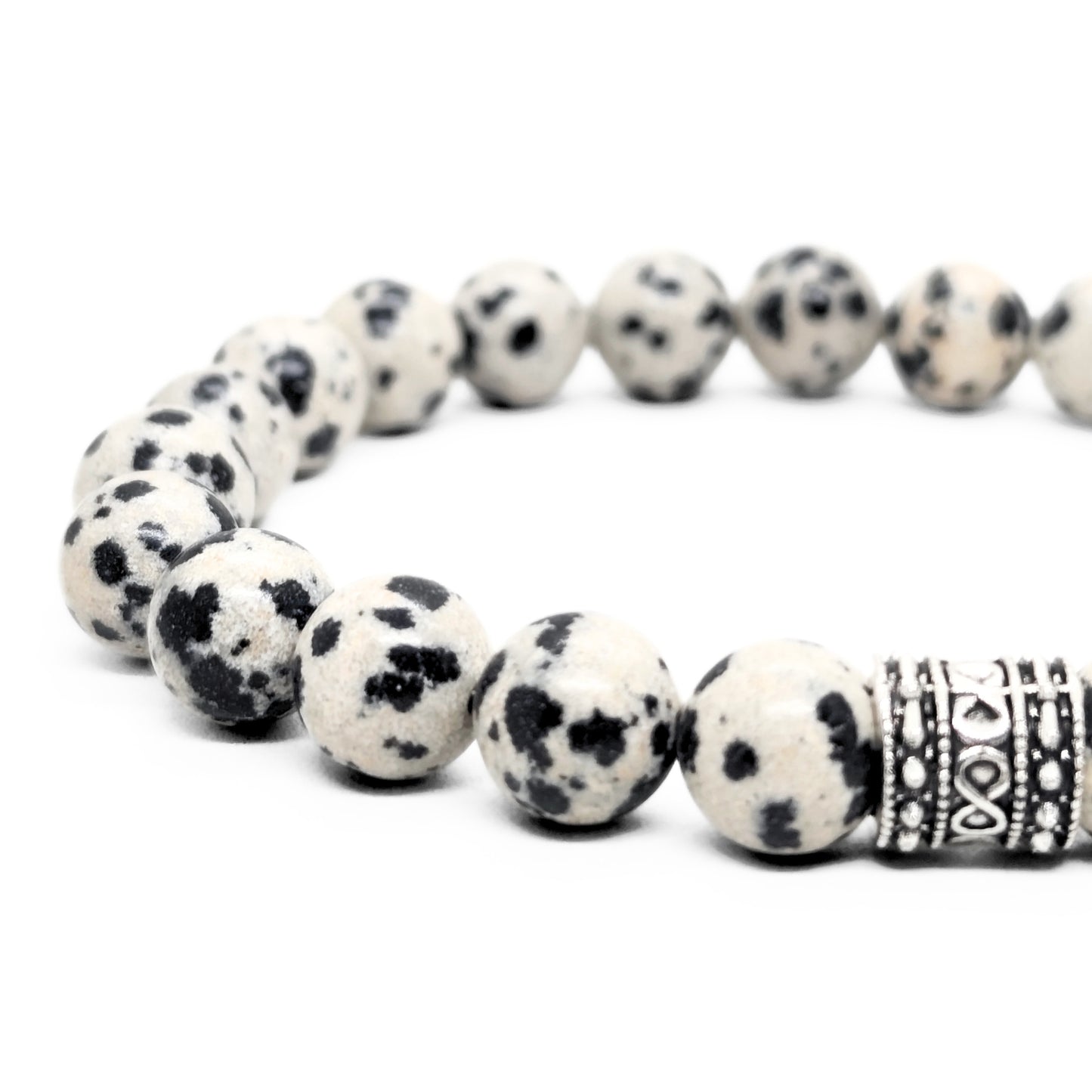 Dalmatian jasper bead bracelet close view, speckled beads and engraved silver-tone center