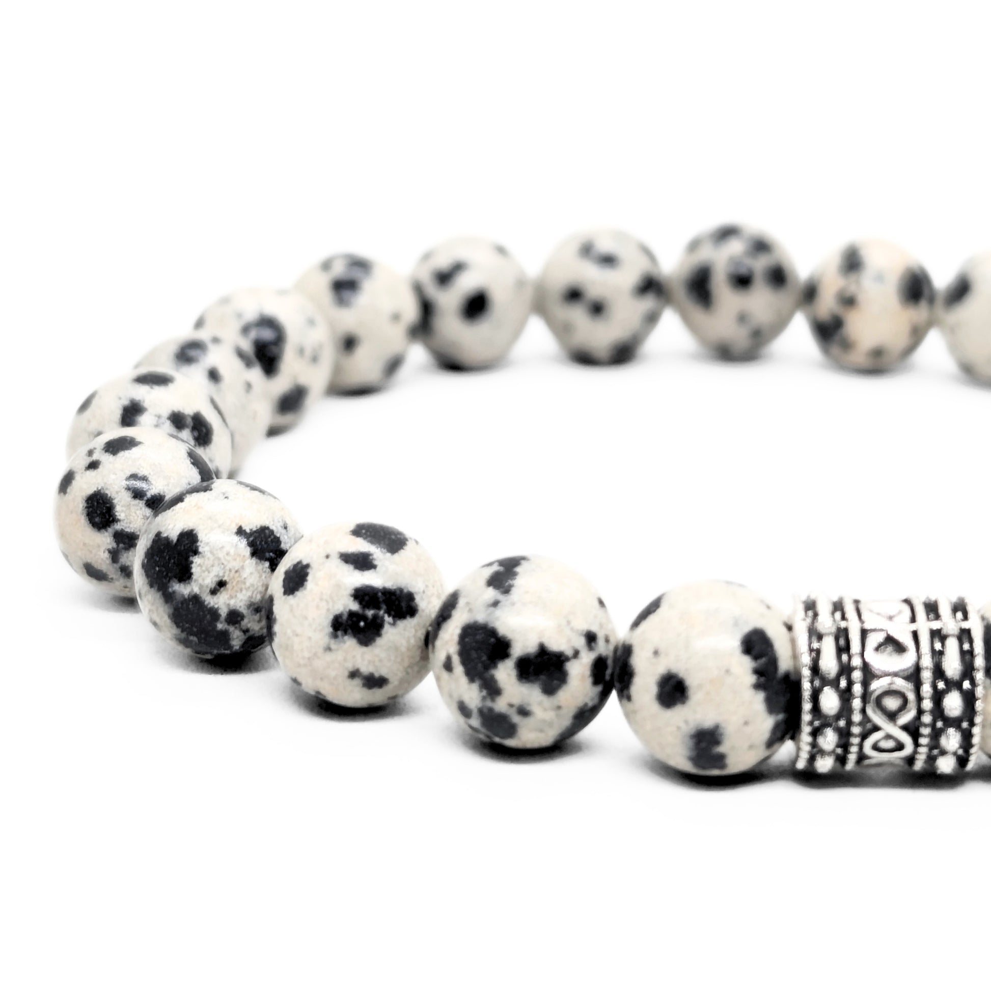 Dalmatian jasper bead bracelet close view, speckled beads and engraved silver-tone center