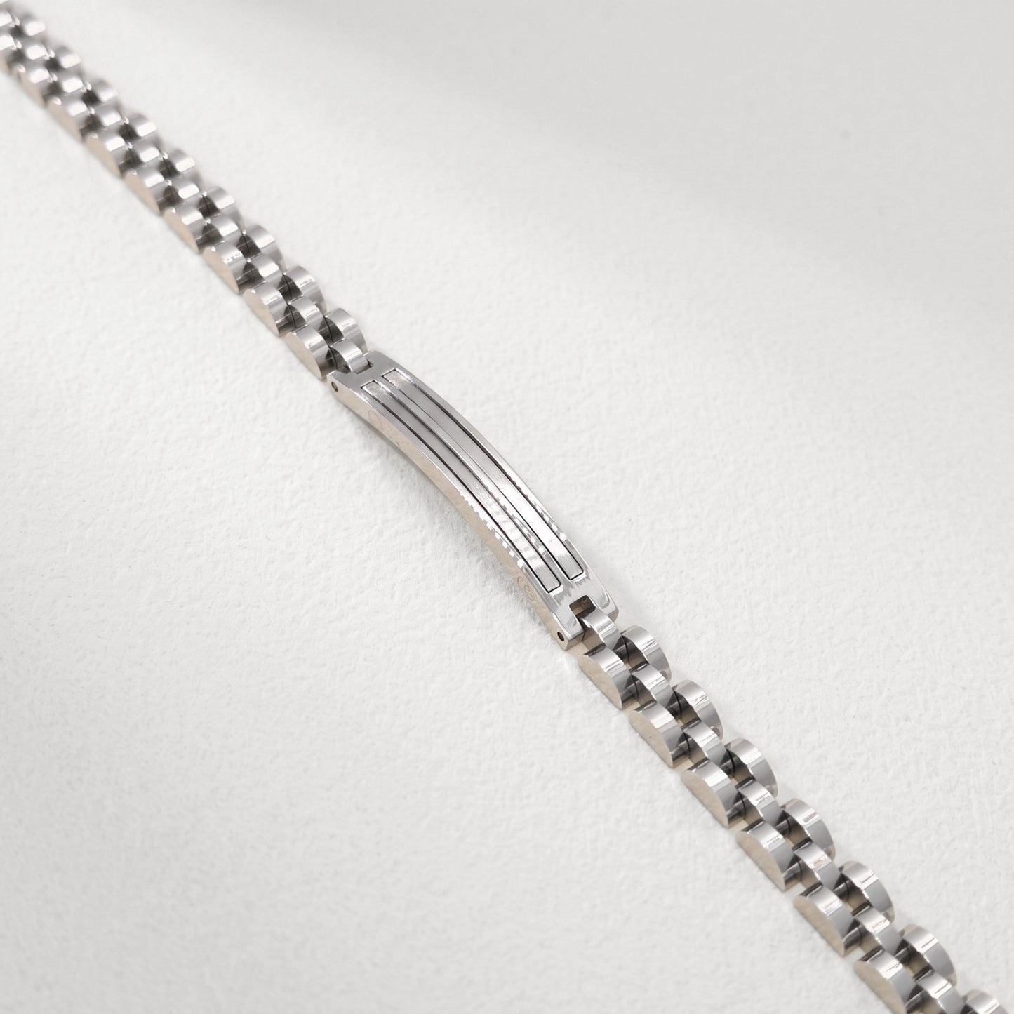 Close-up of silver stainless steel bracelet center panel with engraved horizontal lines