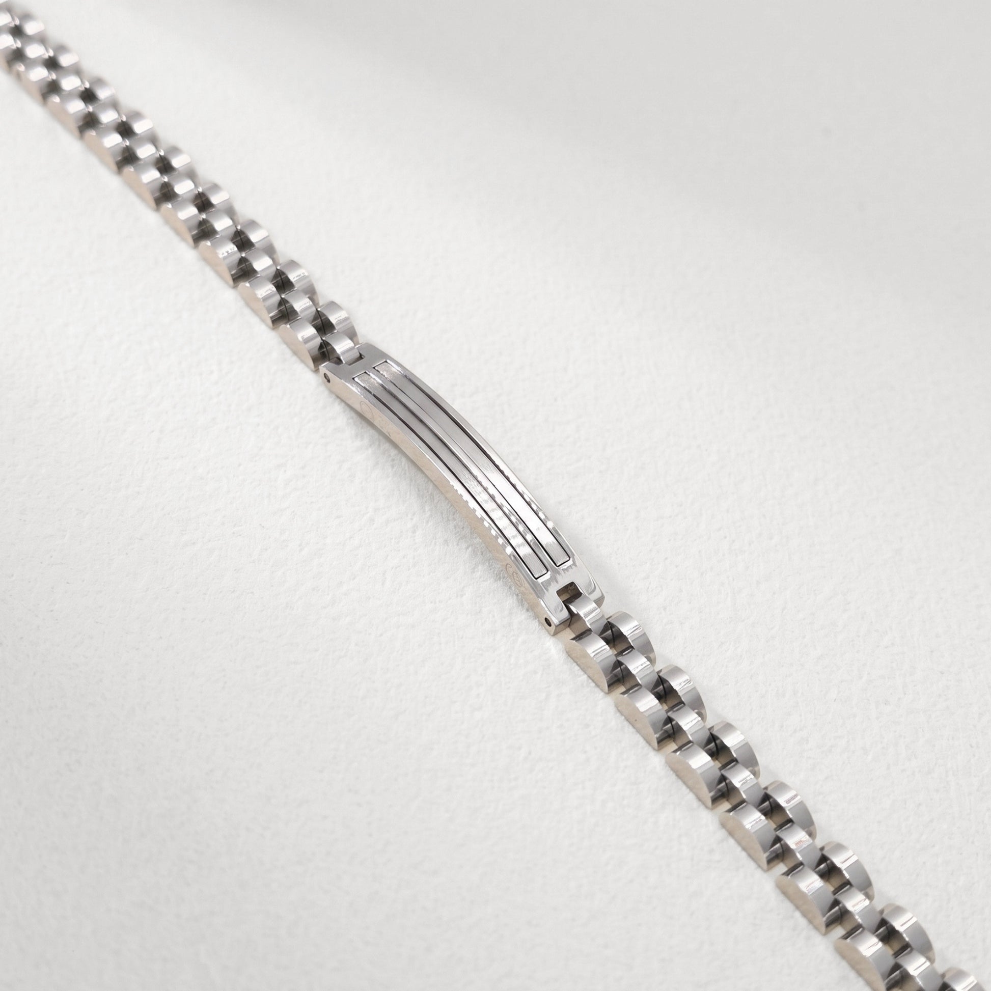 Close-up of silver stainless steel bracelet center panel with engraved horizontal lines