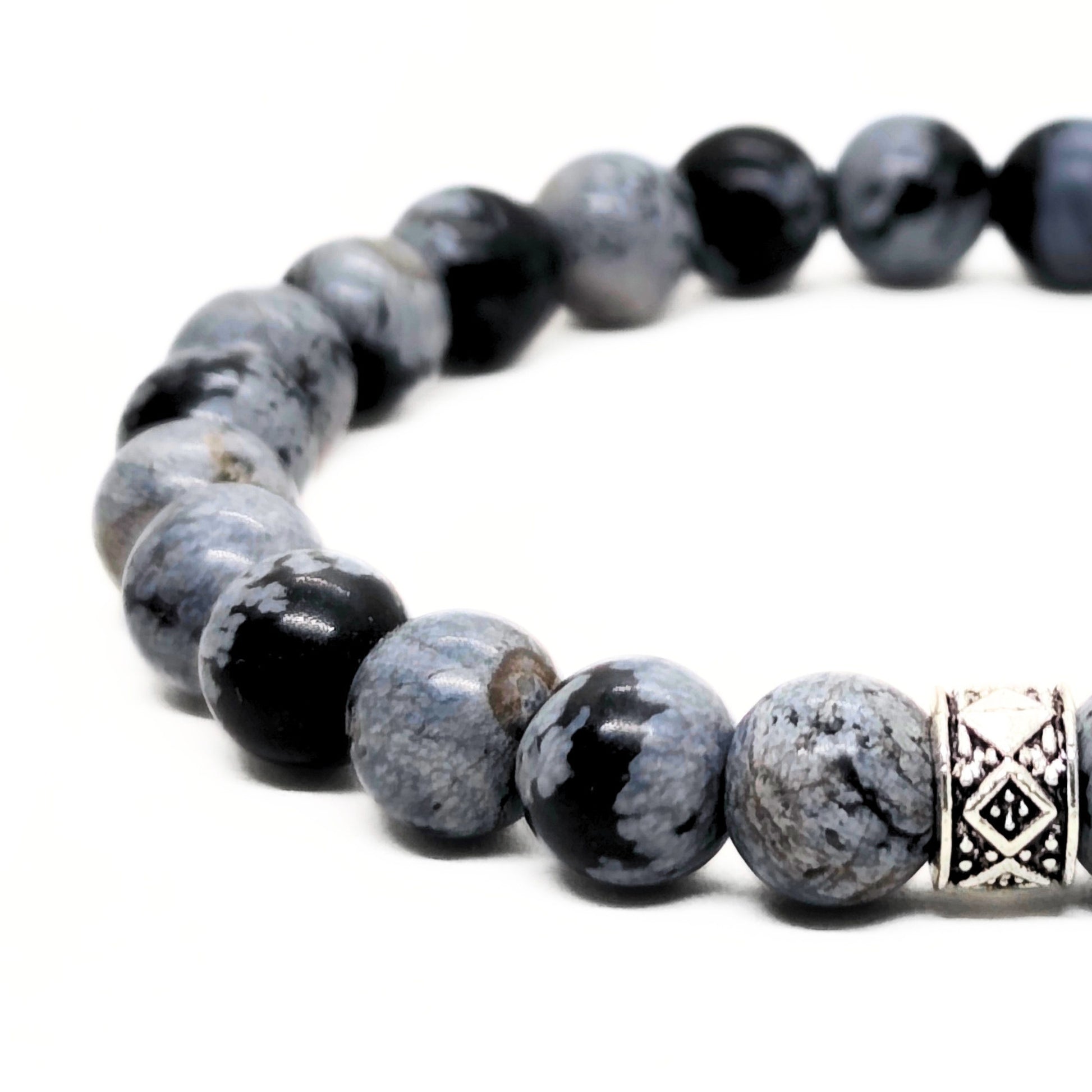 Close-up: gray obsidian bead bracelet with black accents and a silver geometric centerpiece