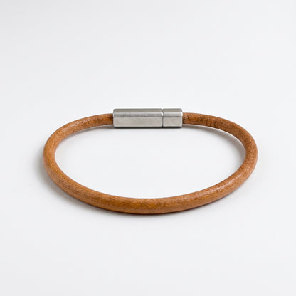 Beige-brown leather bracelet with silver magnetic bar clasp, flat on white