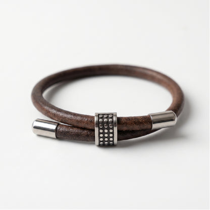 Men's brown leather bracelet with silver end caps and square studded clasp centerpiece