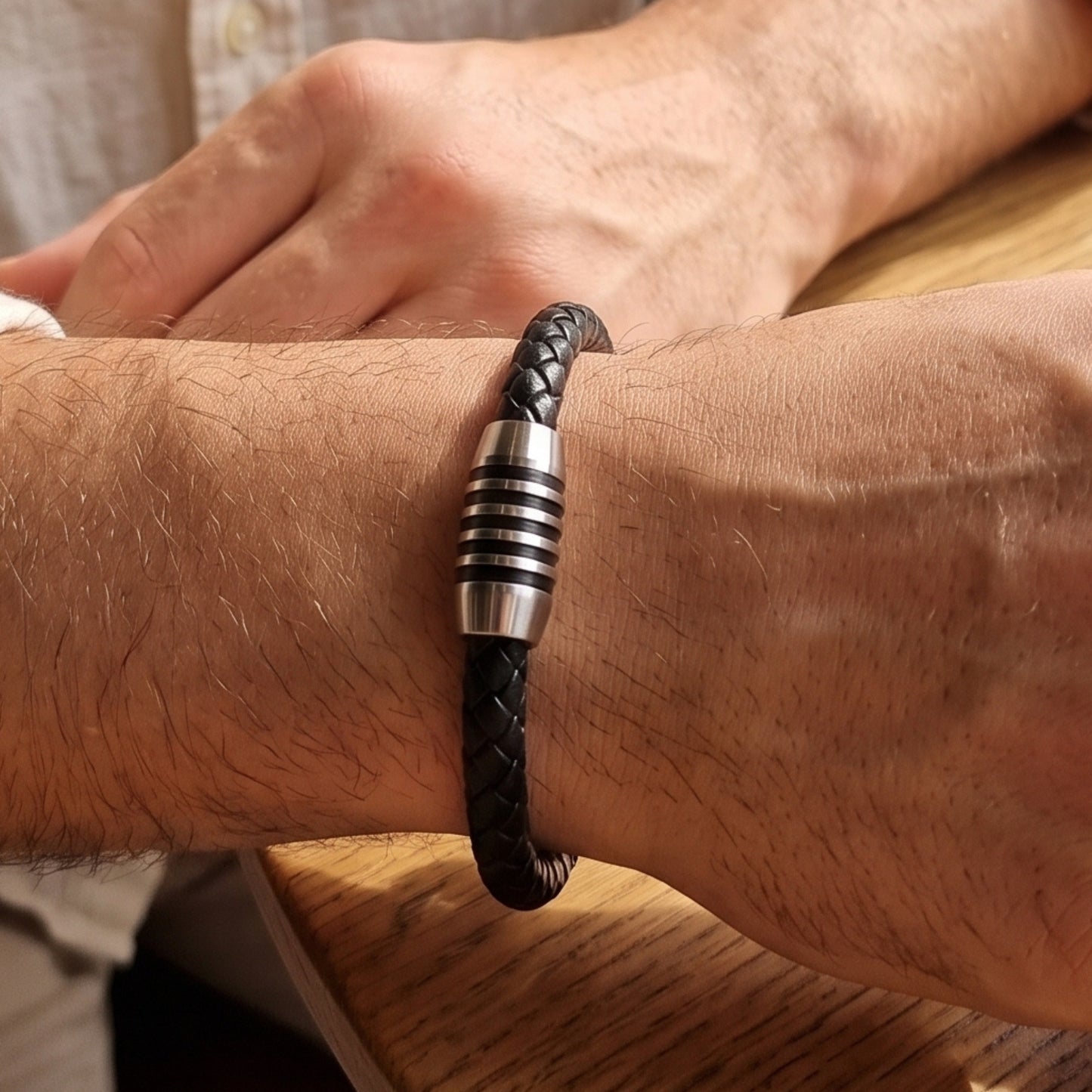 Black braided leather bracelet with silver-tone ringed clasp on wrist