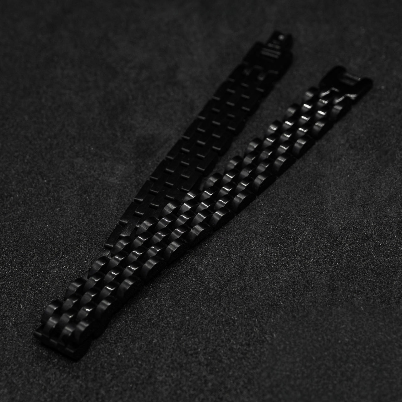Sleek Black Stainless Steel B-16 Bracelet by Overpowered Accessories, featuring a woven design on a dark background.