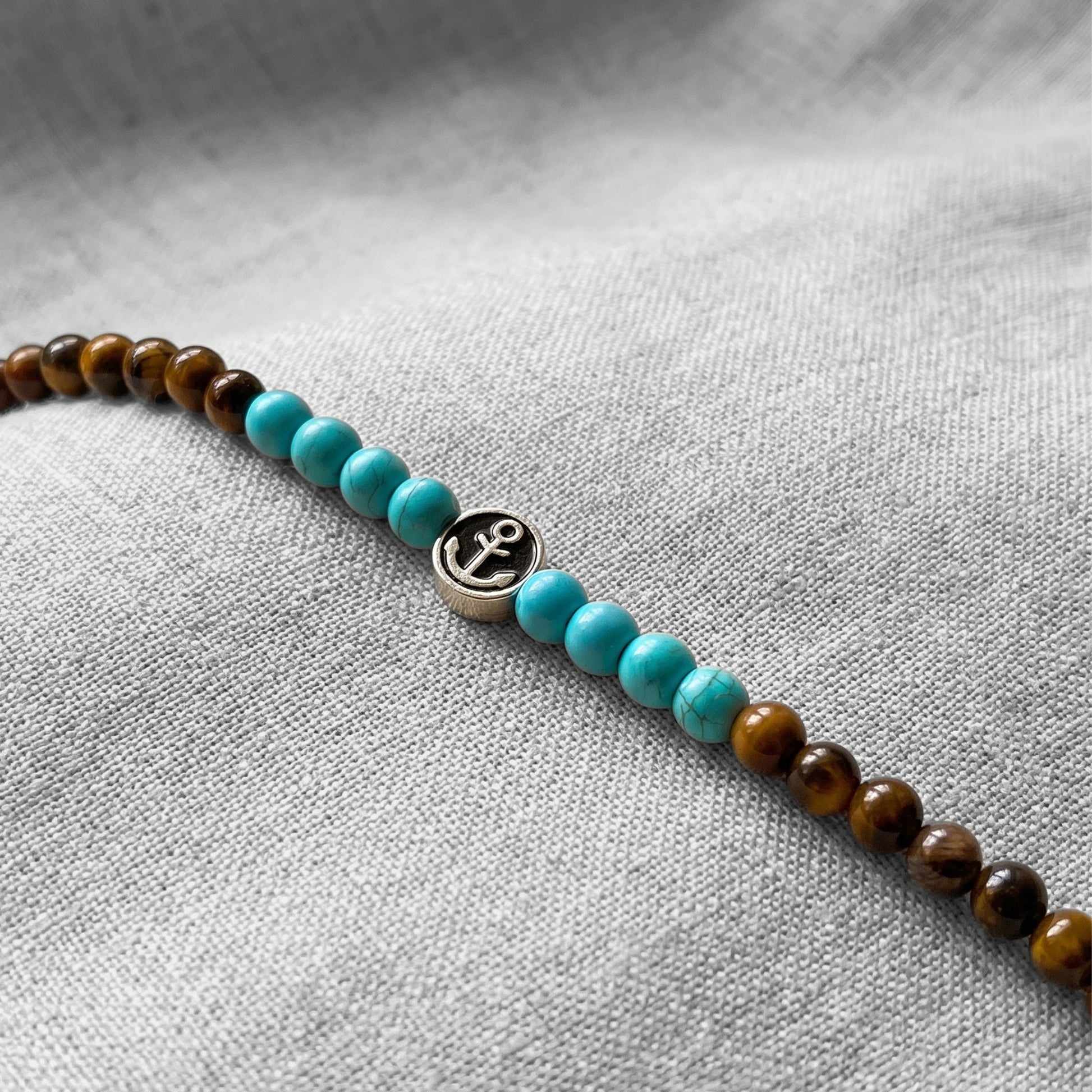 Men's turquoise and tiger eye bead bracelet with round silver anchor charm detail