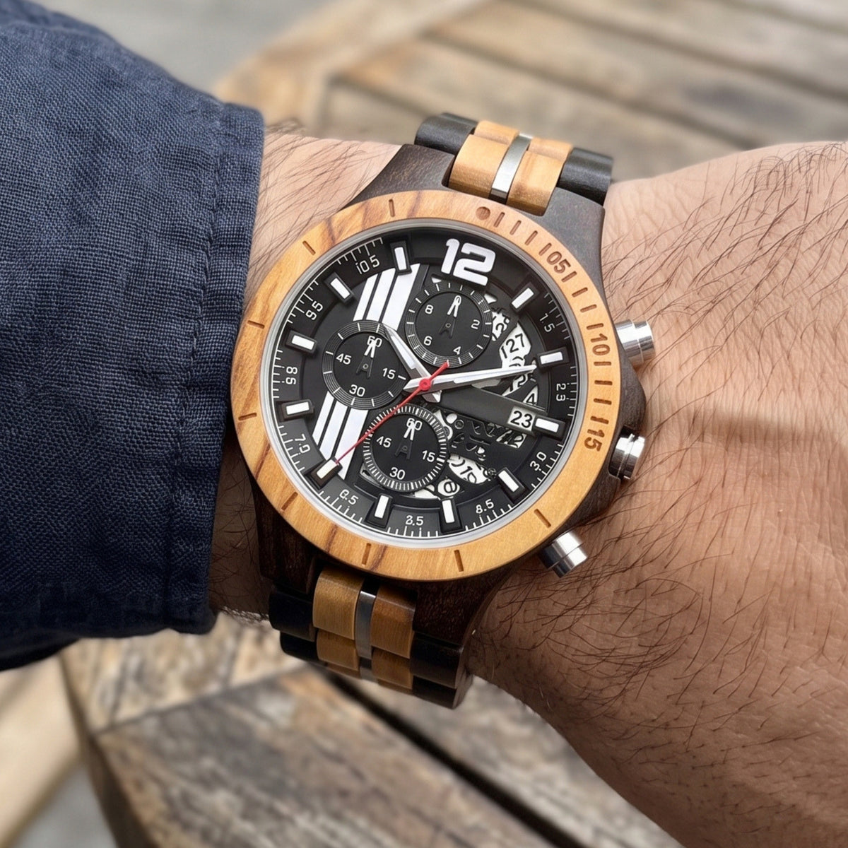 Men's wood sport watch on arm with black dial, red second hand, and silver side button.