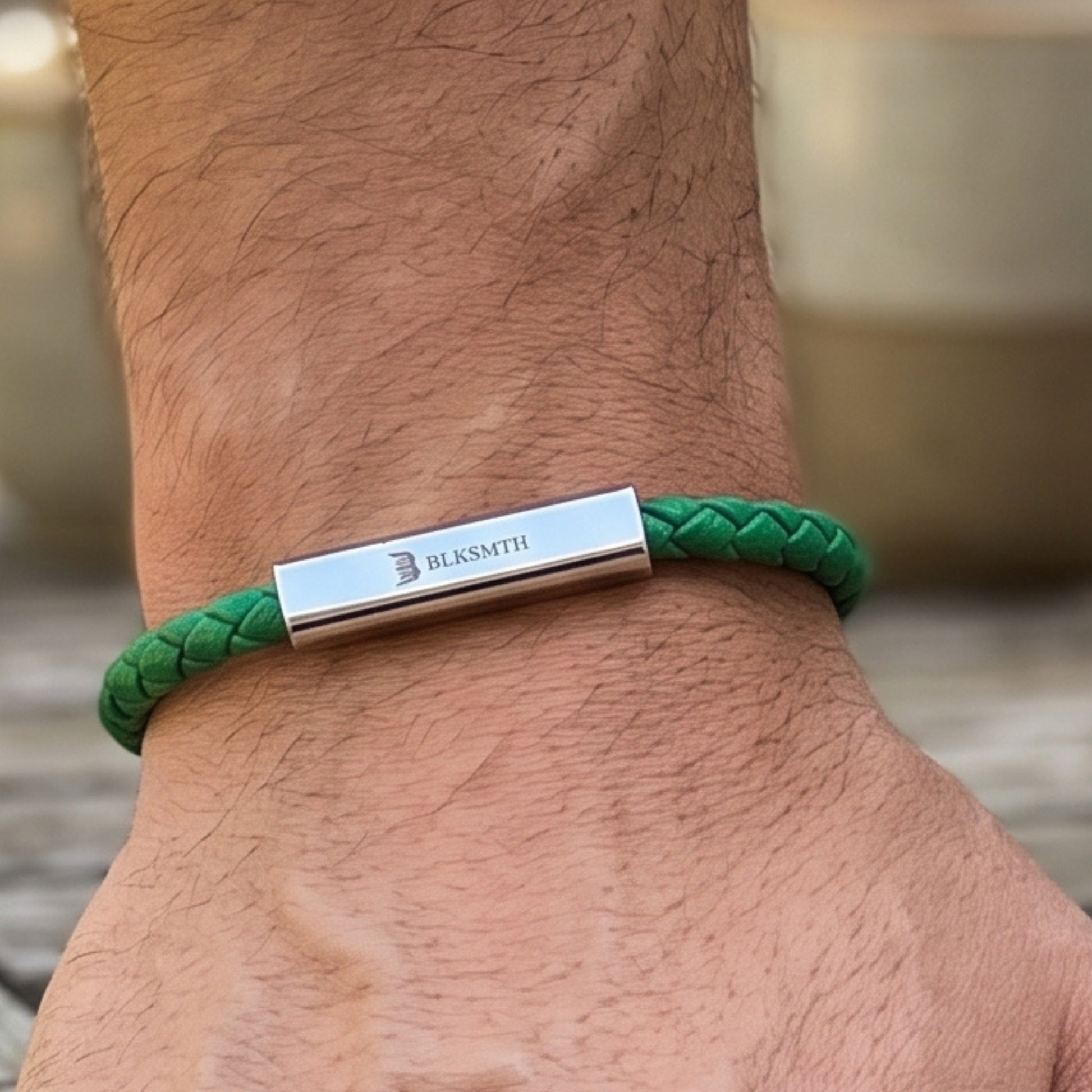 Green braided leather bracelet with silver bar clasp centered on wrist