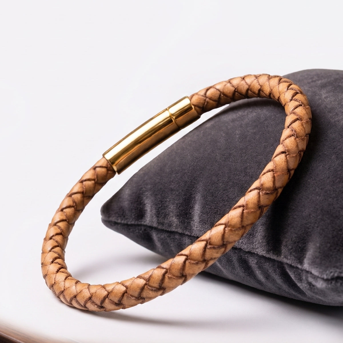 إسورة جلد بني فاتح مضفّر بقفل دهبي على مخدة غامقة، Overpowered Accessories