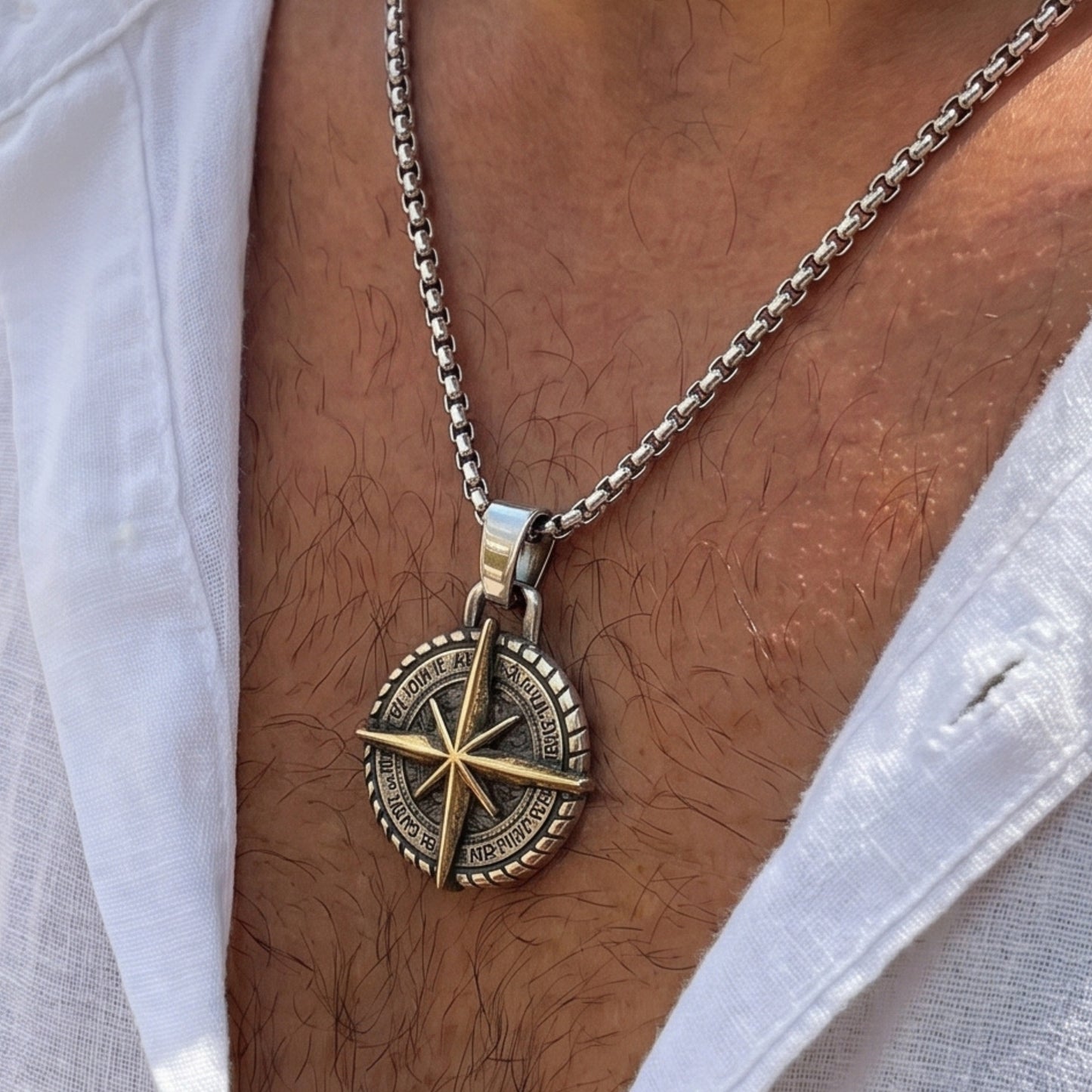 Two-tone compass pendant necklace on chest: dark round dial with gold compass rose, silver chain