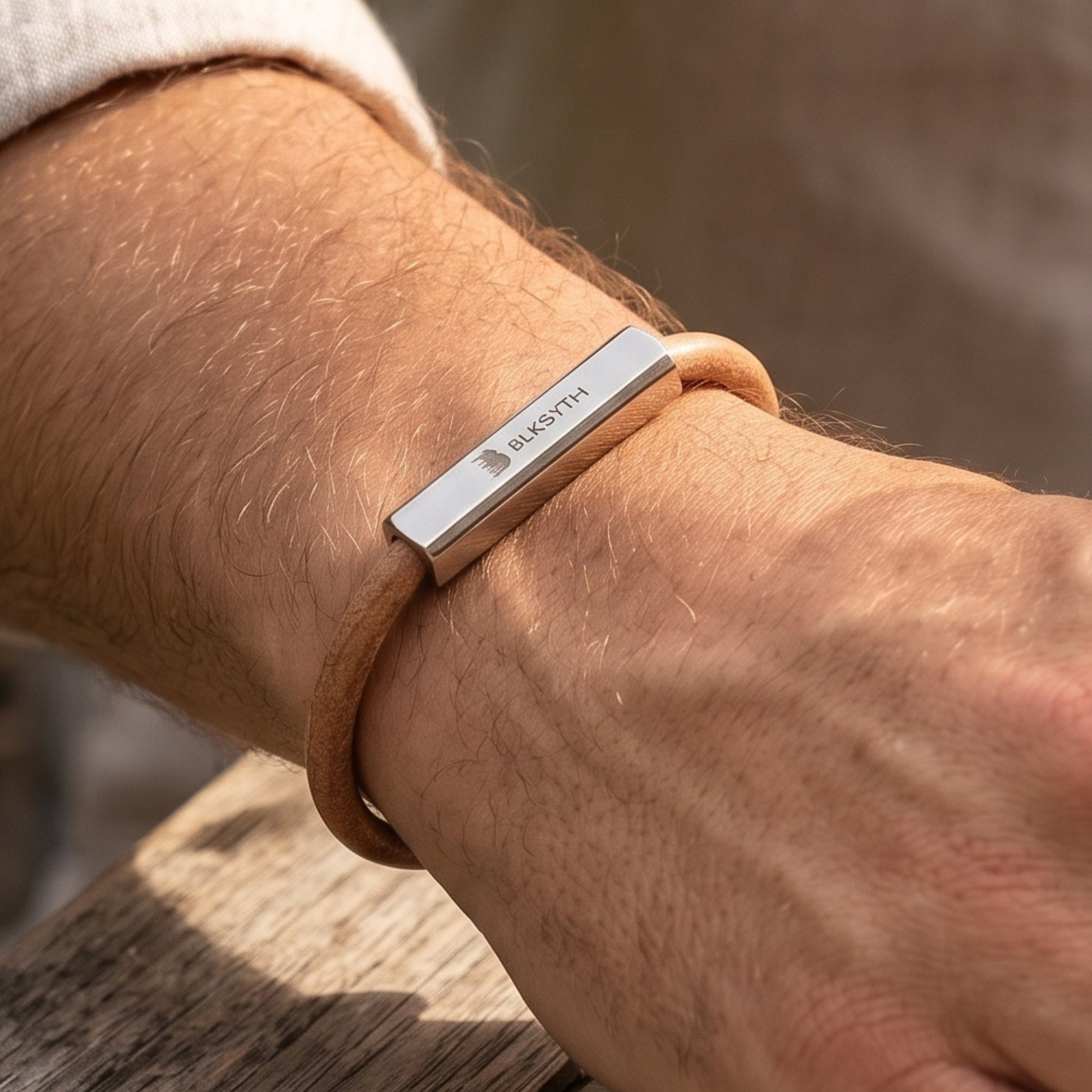 Beige-brown leather bracelet with engraved silver bar, close-up on wrist
