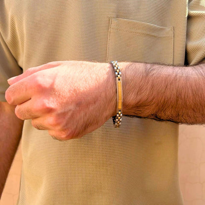 Two-tone silver and gold stainless steel B-75 bracelet worn on a man's wrist, showcasing a stylish design.