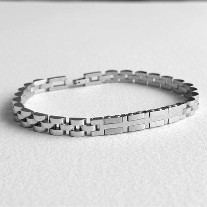 Silver stainless steel bracelet laid flat, link chain with alternating raised plates