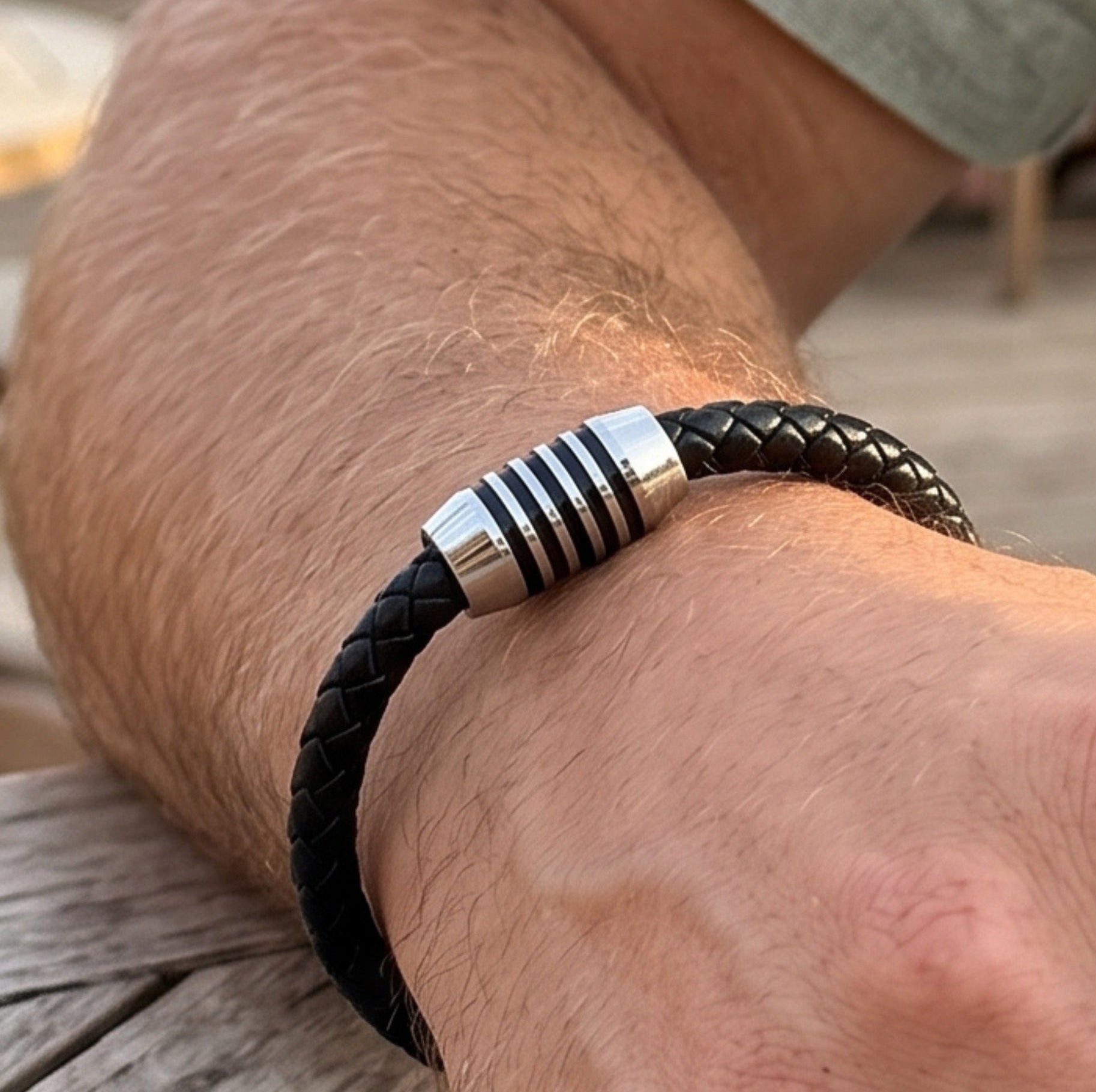 Black braided leather bracelet featuring a silver-tone cylindrical ring clasp