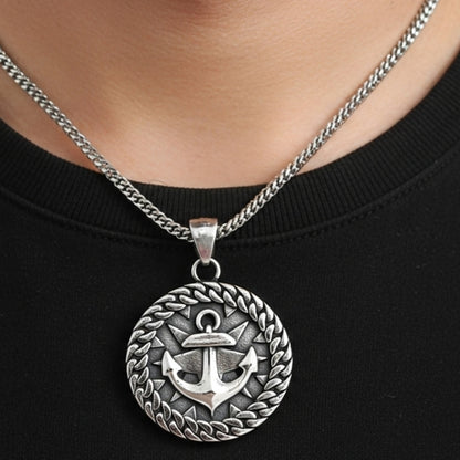 Silver steel anchor pendant necklace with a detailed anchor design surrounded by a laurel wreath, worn on a black shirt.