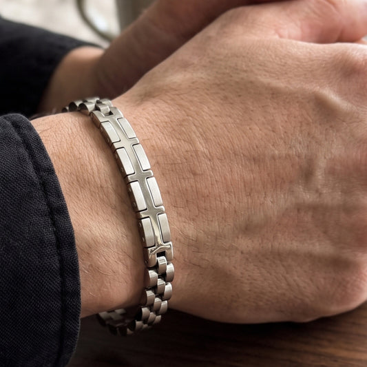 Silver stainless steel bracelet with X-shaped link panels on a man's wrist
