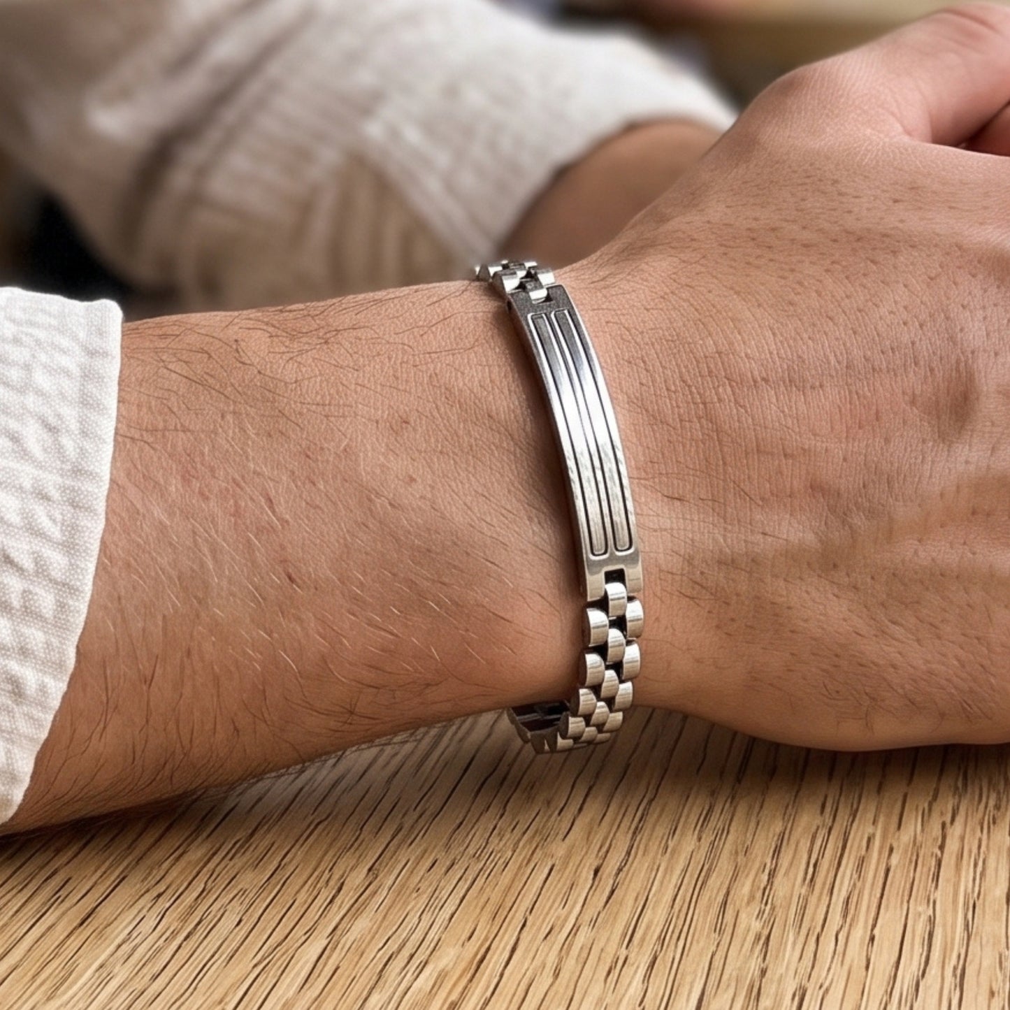 Silver stainless steel bracelet on wrist, side profile showing center bar detail