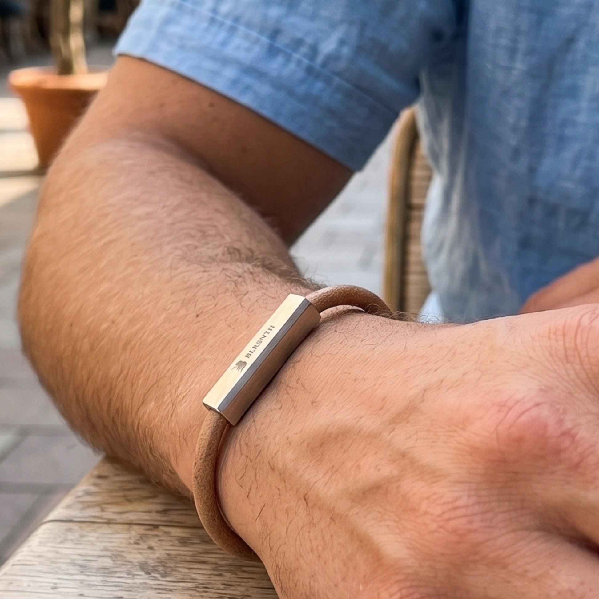 Men's beige-brown leather bracelet with silver bar detail on forearm