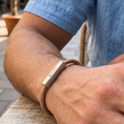 Men's beige-brown leather bracelet with silver bar detail on forearm