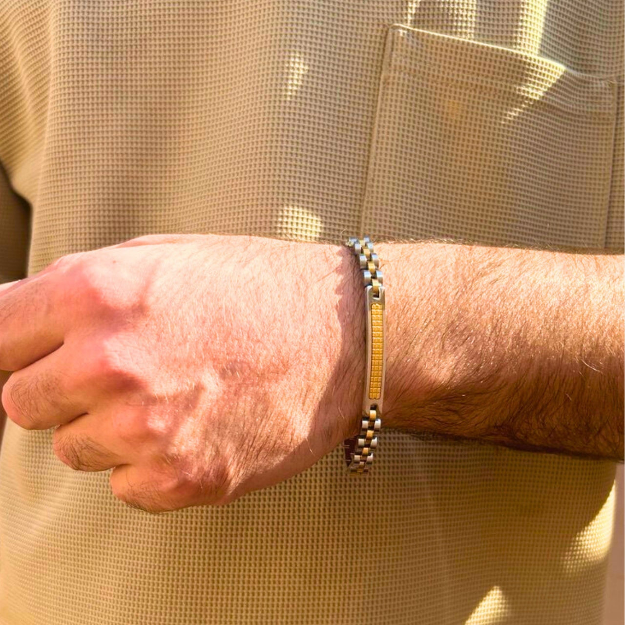 Two-tone silver and gold stainless steel B-75 bracelet worn on a man's wrist, showcasing a sleek design.