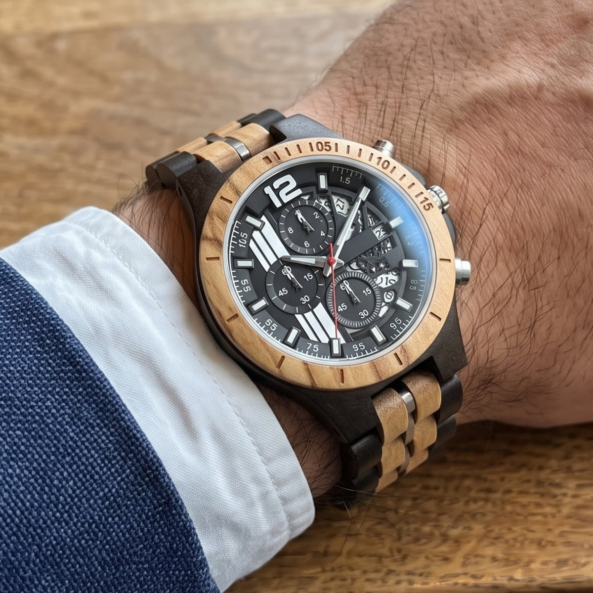 Men's wood sport watch on wrist, dark wood links with tan inserts and black chronograph dial.