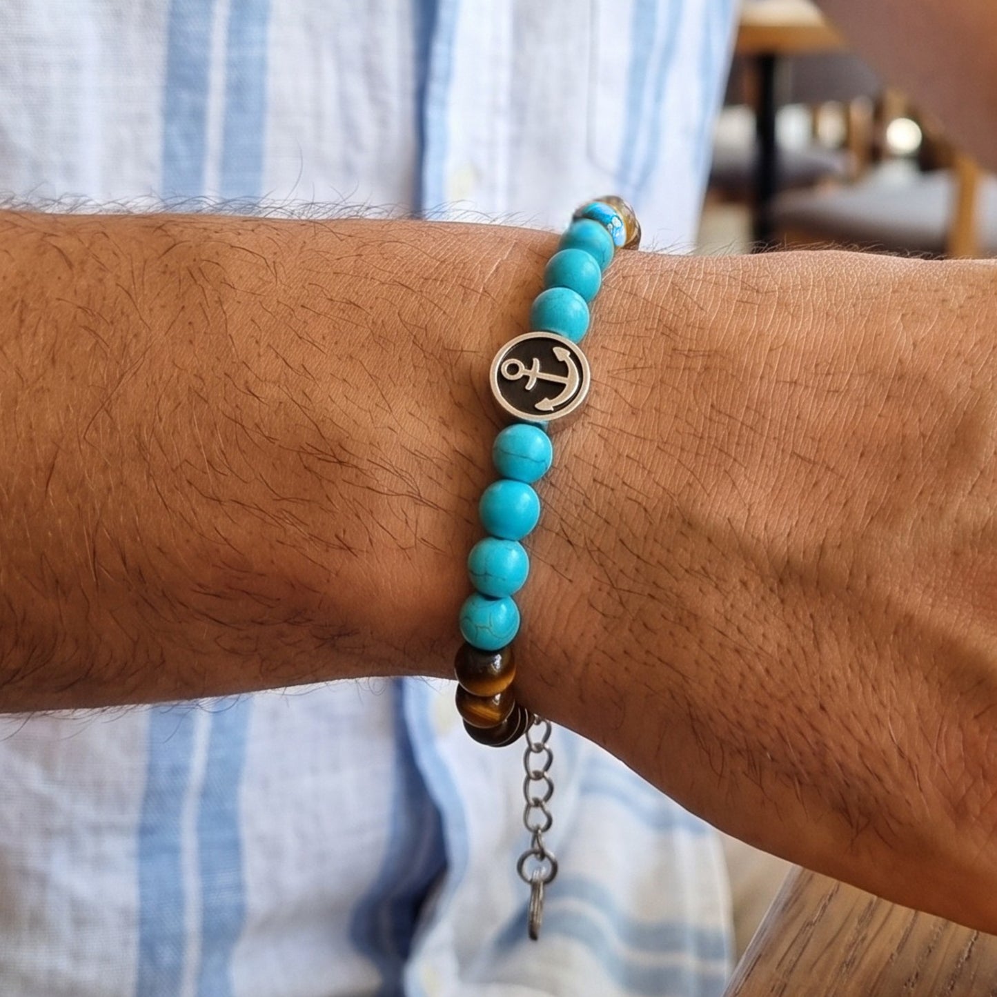 Men's tiger eye and turquoise anchor bracelet worn on wrist with round anchor charm